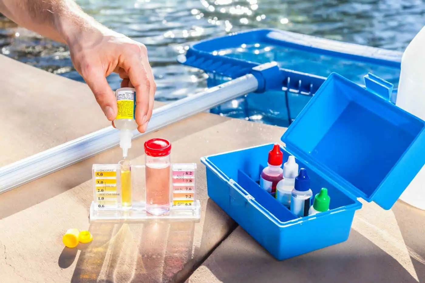 Person testing pool water quality with a chemical testing kit
