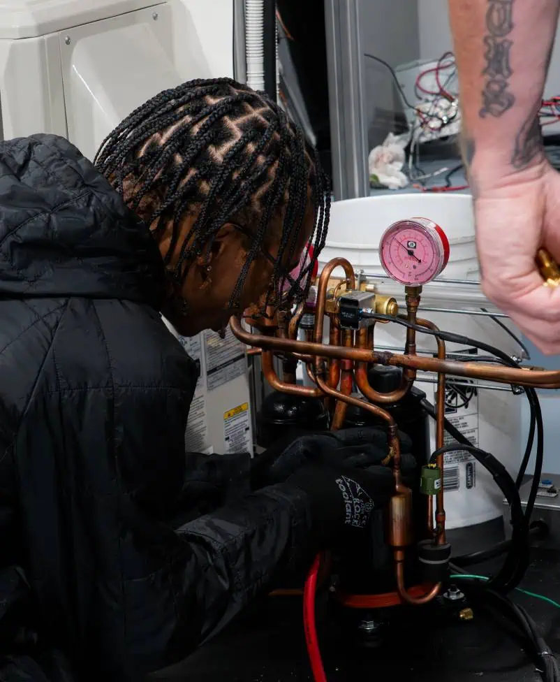 Person working on copper pipes with tools in a workshop